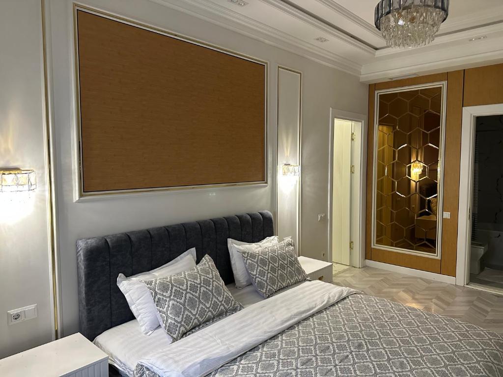 a bedroom with a bed with pillows on it at Luxury Apartment Tashkent City boulevard Happy Home in Tashkent