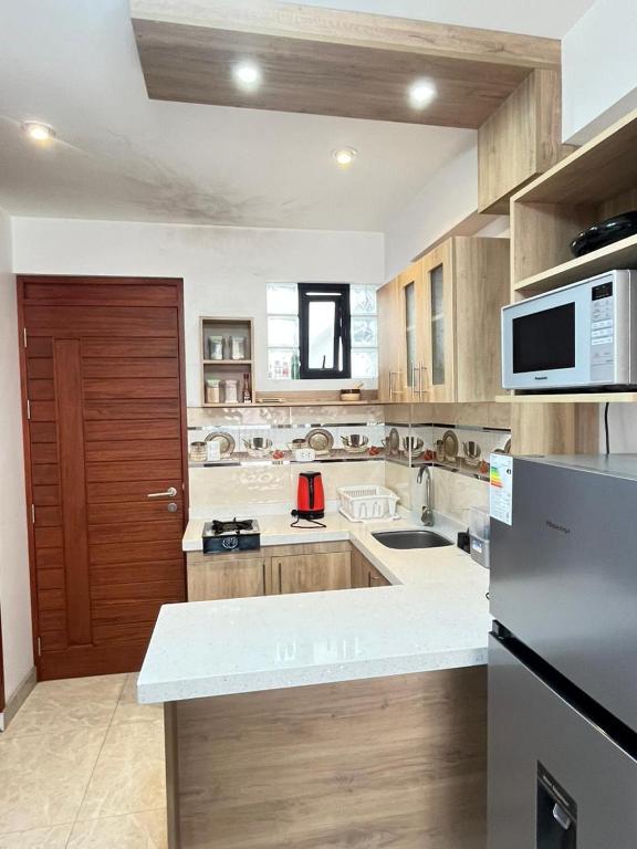 a kitchen with a sink and a microwave at Aparthotel Cusco in San Antonio
