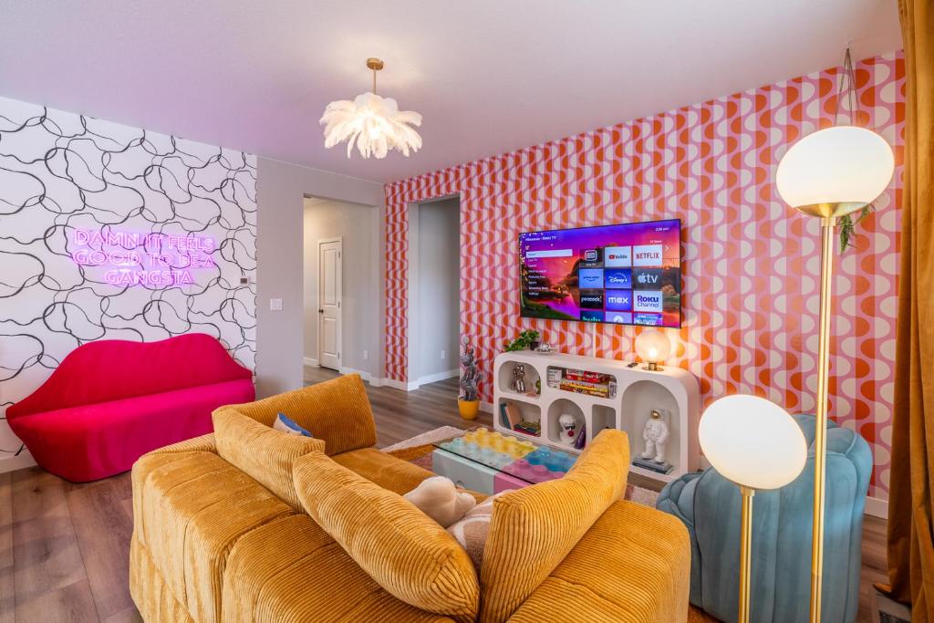 a living room with a couch and a tv at Near Airport, 3BR, Stock Tank Pool, Mini-Golf, Game Rm in Commerce City