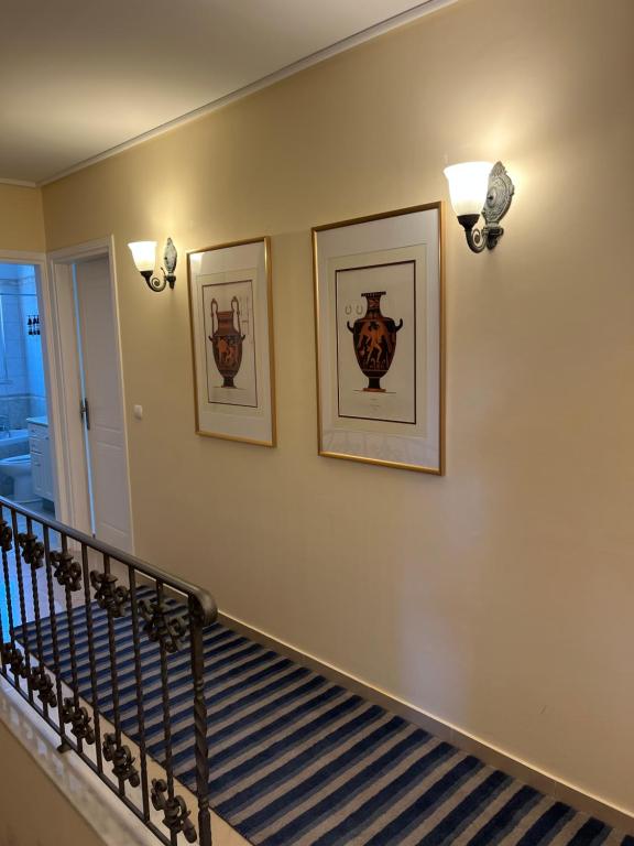 a stairway with two pictures on the wall and two lights at Villa Erato in Rafina