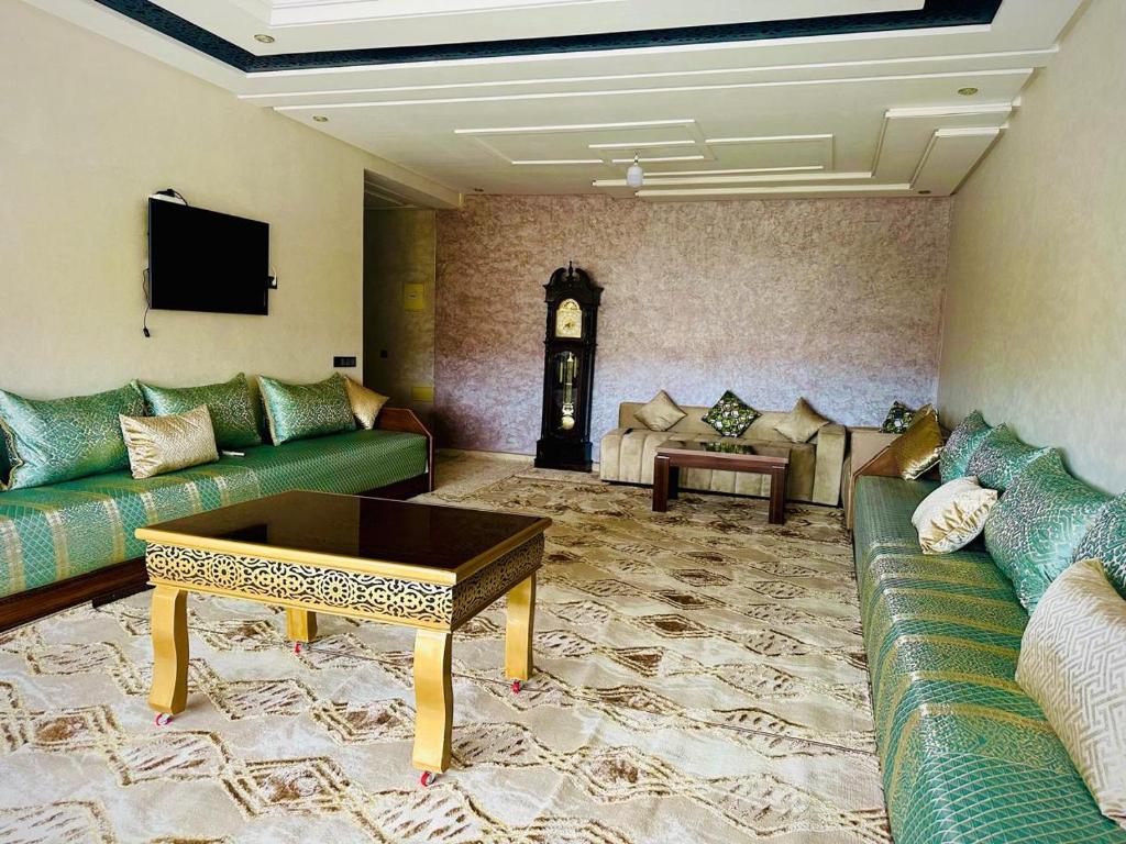 a living room with green couches and a clock at إقامة حسن in Fez