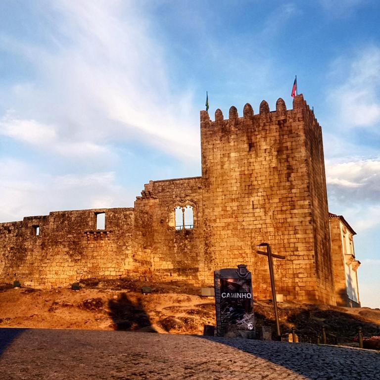 an old castle with a flag on top of it at Casa da Massada in Belmonte