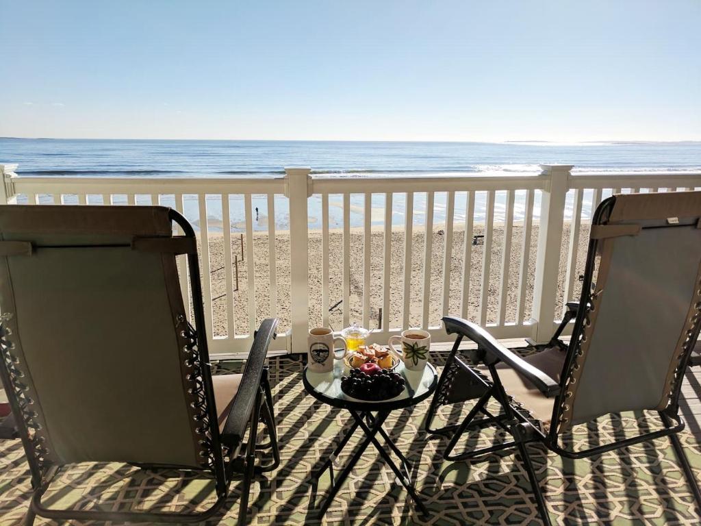 two chairs and a table on a balcony with the beach at Beachfront Condo with Amazing Ocean Views 4th Fl in Old Orchard Beach