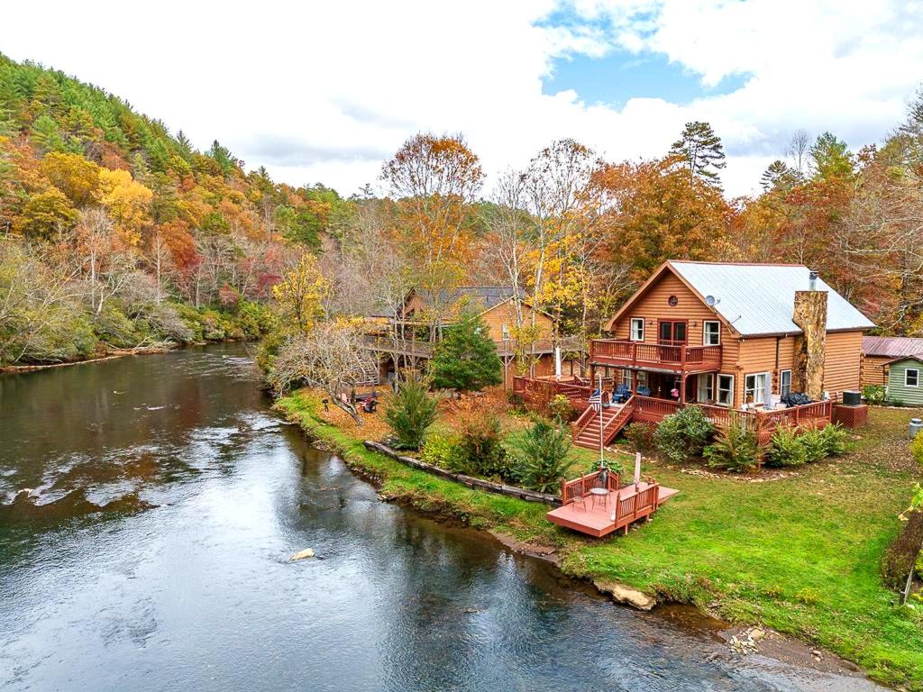 a house next to a river with a house at Kingfisher's Cabin 15 Minutes to Casino Hot tub Firepit in Murphy