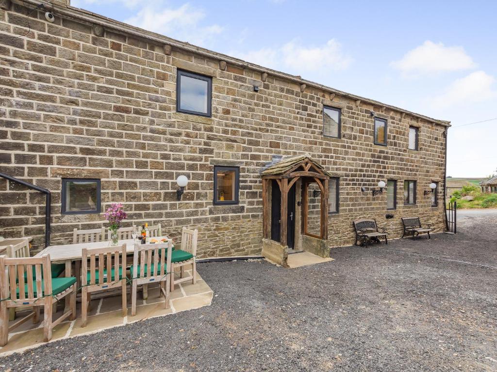 a brick building with benches in front of it at The Barn in Keighley