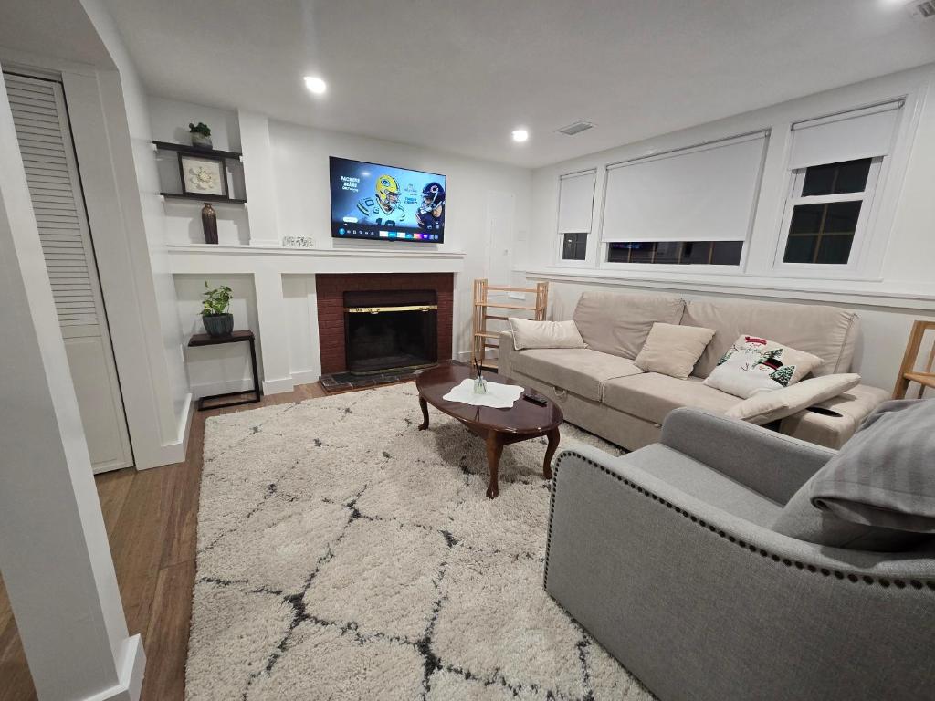 a living room with a couch and a fireplace at Modern & Cozy Suite in Norwood