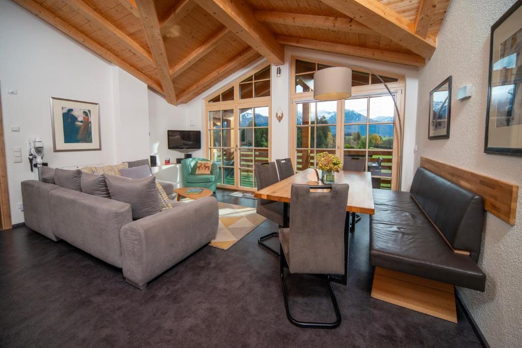a living room with a couch and a table at Traumferienwohnung Alpenliebe Sommer-Hörnerbahnen kostenlos in Bolsterlang