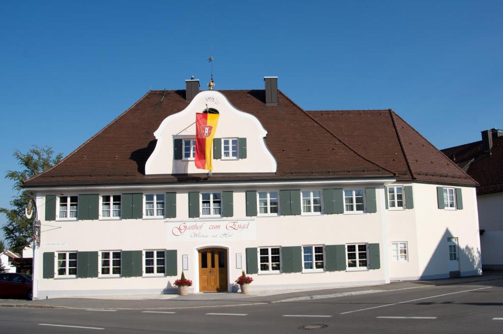 a large white building with a brown roof at Gasthof Engel in Kaufbeuren