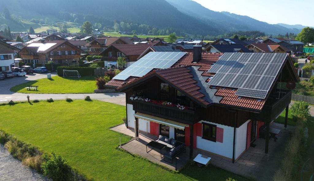 an image of a house with solar panels on the roof at Ferienhaus Alpenherz Sommer-Bergbahnen-kostenlos in Bolsterlang