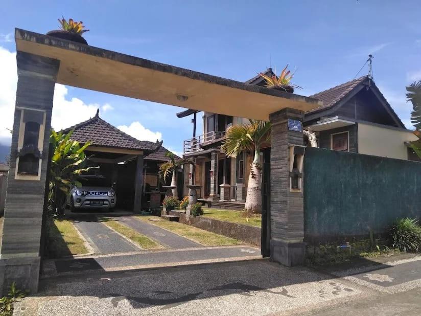 a house with an archway in front of it at Homestay Mroom Bali in Perean