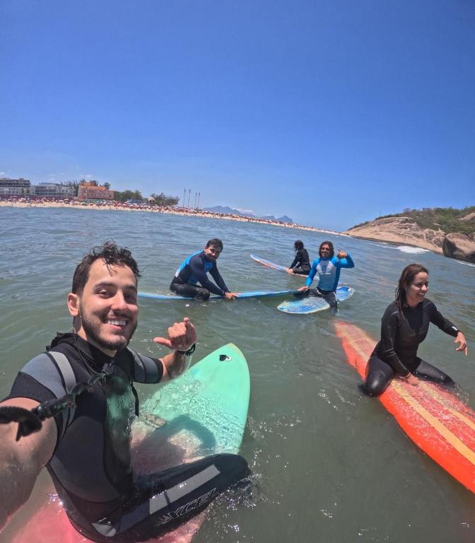 a group of people sitting on surfboards in the water at Leal Surf School in Rio de Janeiro