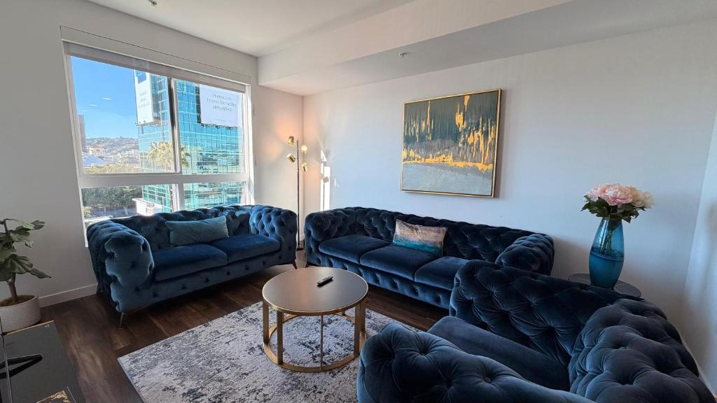 a living room with two blue couches and a table at Volar Luxurious #328 in Los Angeles