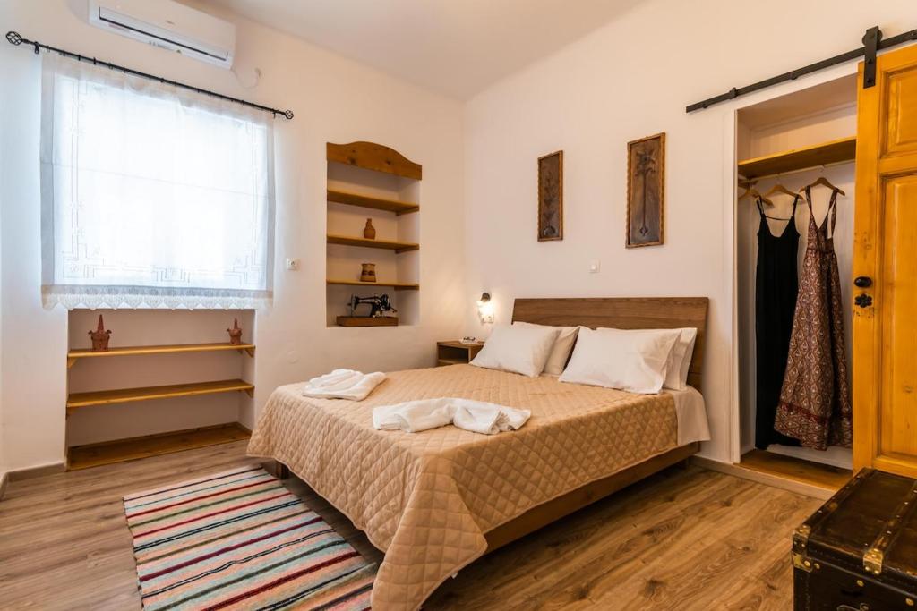 a bedroom with a bed and a window at Casa de Flores 2 in Plaka Milou