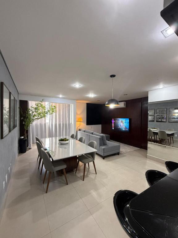 a living room with a table and a couch at Sublime Mognos Apartment - Bosque Saúde in Cuiabá