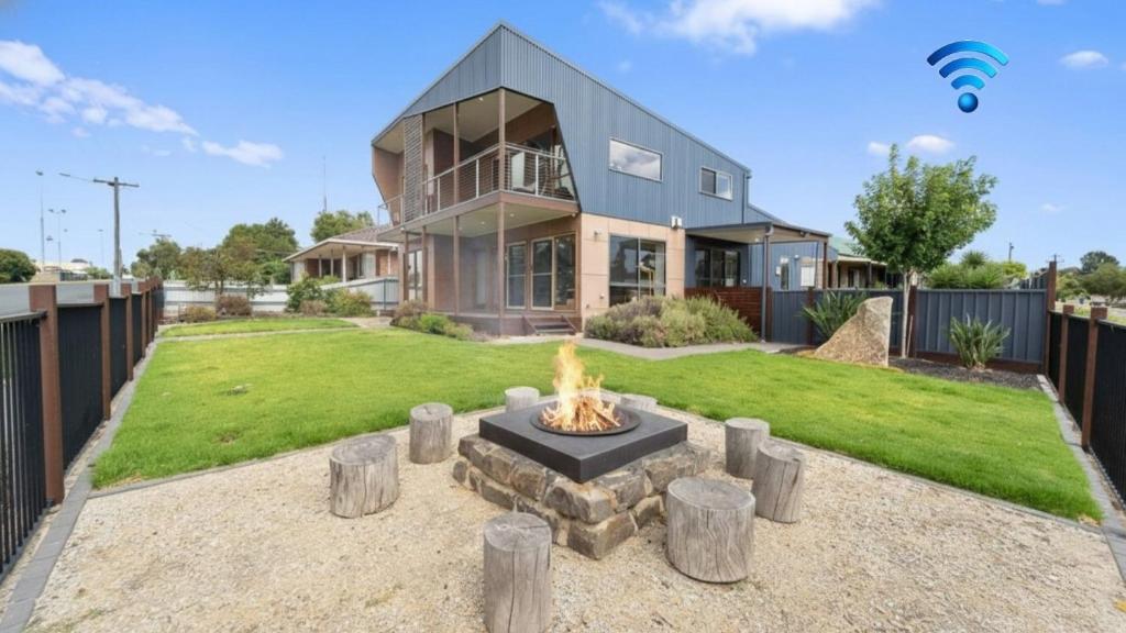 a house with a fire pit in the yard at Bendigo Lakeside in Eaglehawk