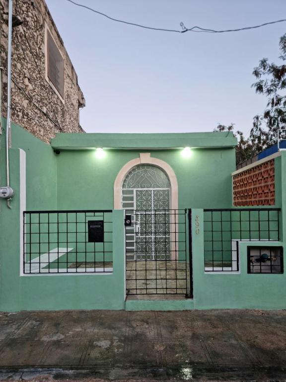 a green house with a gate in front of it at Merida Centro House with Private Pool and Air Conditioning in Mérida