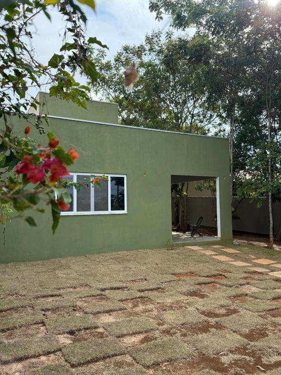a green house with a window on the side of it at Casa 3 Suites Confortaveis in Chapada dos Guimarães