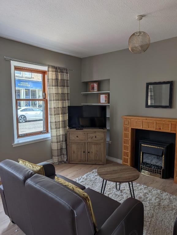 a living room with a couch and a fireplace at Argyll Place in Campbeltown