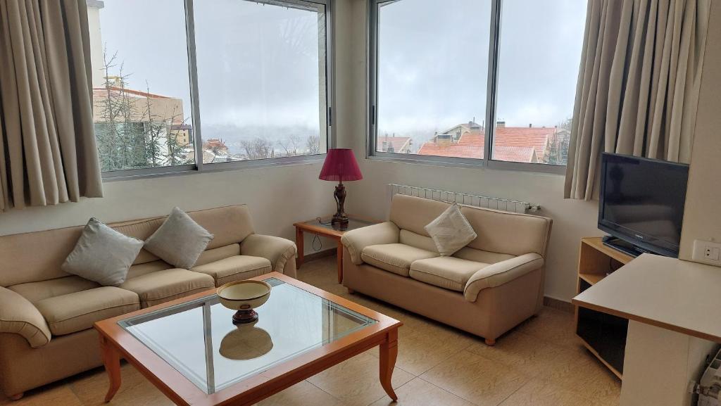 a living room with two couches and a tv at Panoramic 3-Bedroom Chalet with Terrace-Garden in Kfardebian