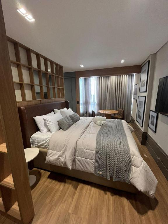 a bedroom with a large bed in a room at Loft de Luxo com Charme e Design Moderno in Cuiabá