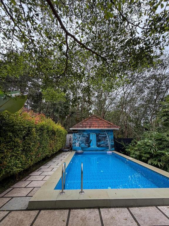 a swimming pool with a gazebo in a yard at Maple grove villa resort in Panamaram