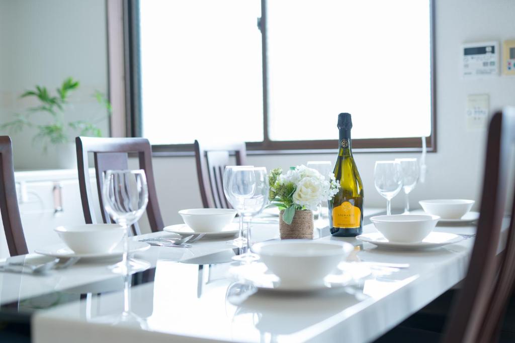 a dining table with a bottle of wine and a bottle of flowers at 禅 Zen 鹿児島 フロア貸切 中央駅徒歩14分 in Yamashitachō