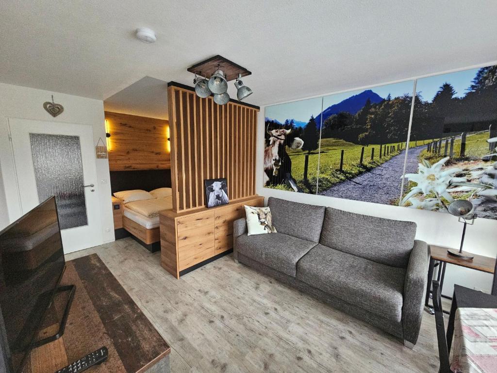 a living room with a couch and a bed at Apartment Rubihornblick - mit Hallenbad und Sauna in Bolsterlang