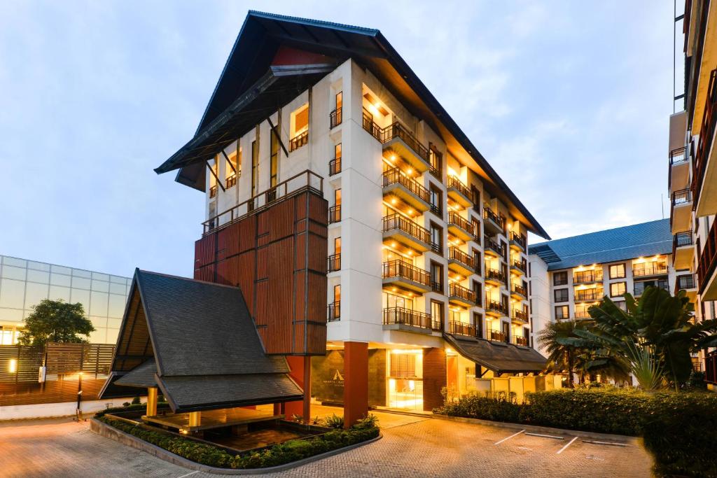 a large white building with a black roof at Amanta Hotel & Residence Ratchada in Bangkok