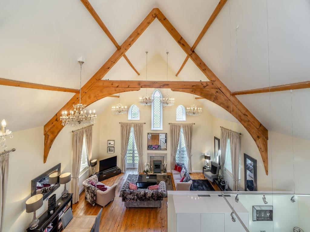 a living room with a large ceiling with wooden beams at The Old Chapel in Ulverston