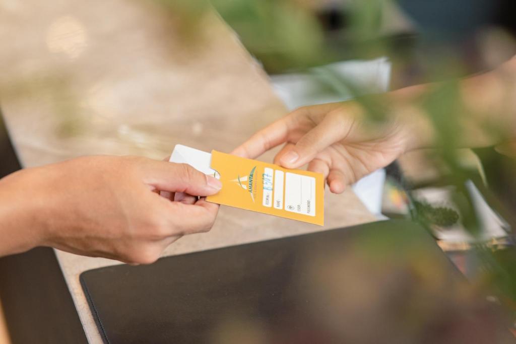 A close-up of a hotel key card being handed across a reception counter.