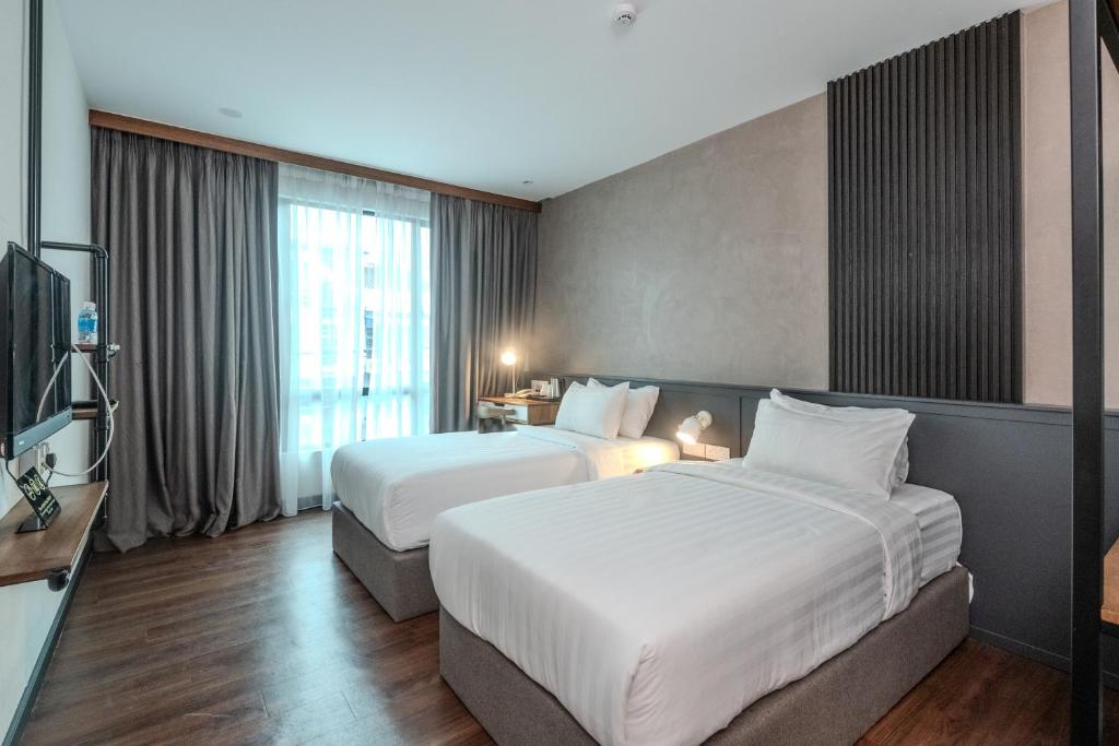 a hotel room with two beds and a television at O&G Hotel Parit Buntar in Parit Buntar