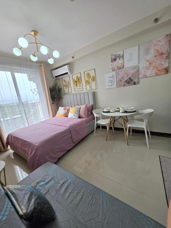 a living room with two beds and a table and a table and chairs at Saekyung Lapu-lapu in Suba