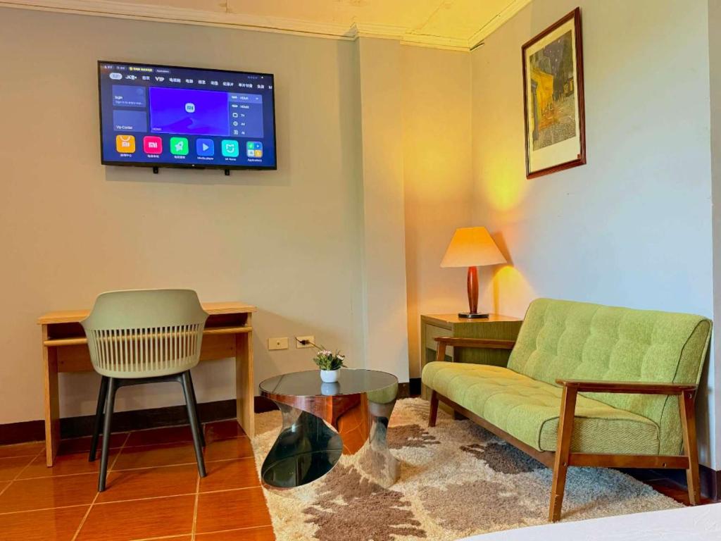 a living room with a couch and a tv on the wall at Chad's Lodge in Coron