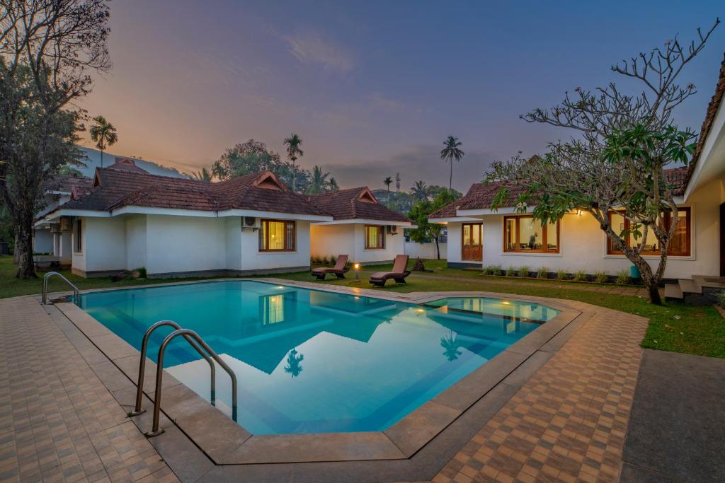 a swimming pool in the backyard of a house at Silver Crest Resort in Thekkady