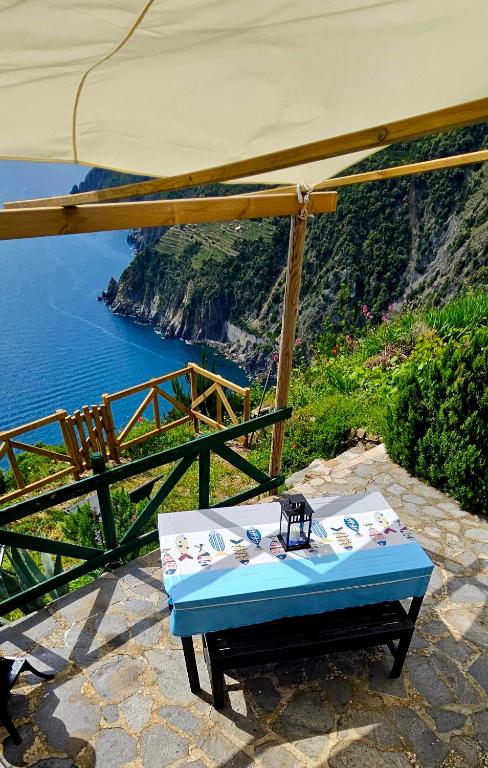 a table under an umbrella with a view of the ocean at Agave di mare in Riomaggiore
