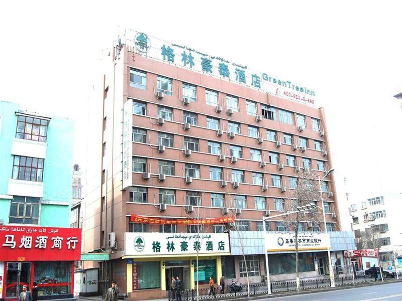 a large red building on a city street at Greentree Inn Wurumuqi South Xinhua Road Hotel in Ürümqi
