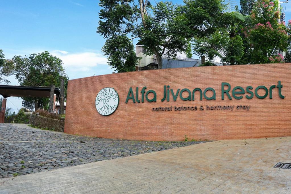 a sign for an alko nana resort on a brick wall at Alfa Jivana Resort in Sampal 2