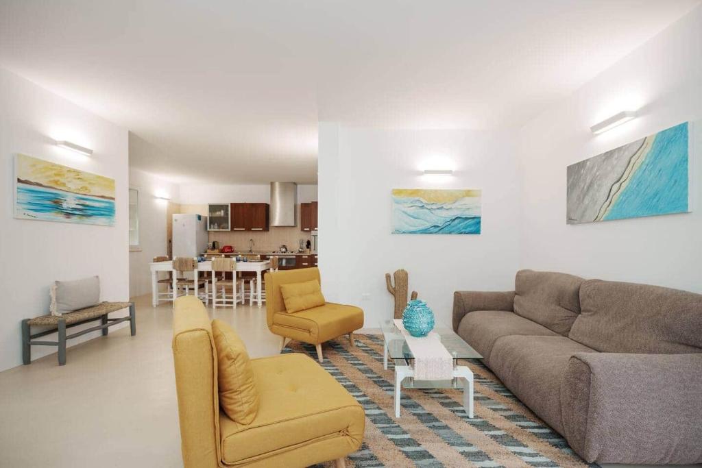 a living room with a couch and chairs and a kitchen at White House – Villa con Jacuzzi e Posto Auto in Otranto