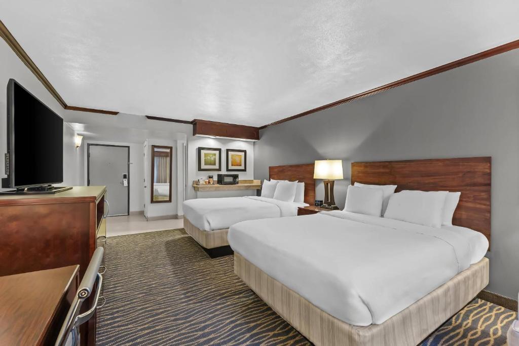 a hotel room with two beds and a flat screen tv at Radisson Hotel Salt Lake City Airport in Salt Lake City