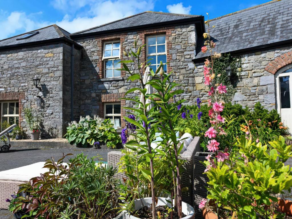 a stone house with flowers in front of it at Coach House in Portlaoise
