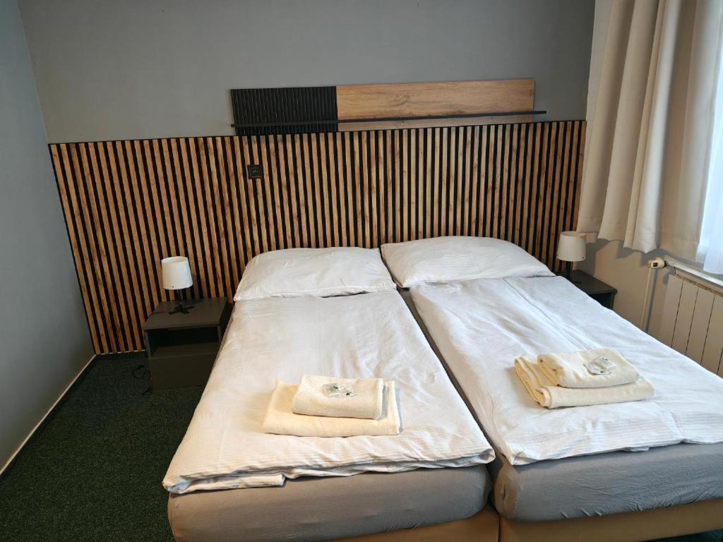a bedroom with two beds with towels on them at HOTEL Tyrapol - izby in Oravská Lesná