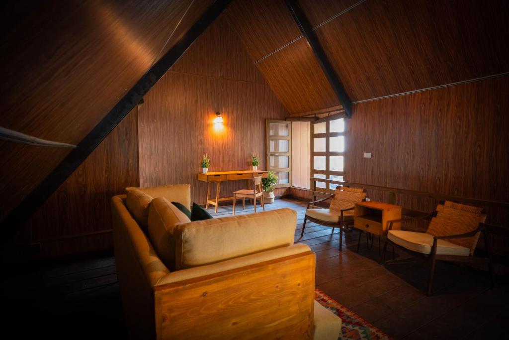 a living room with a couch and a table and chairs at Semari Resort in Muzaffarabad