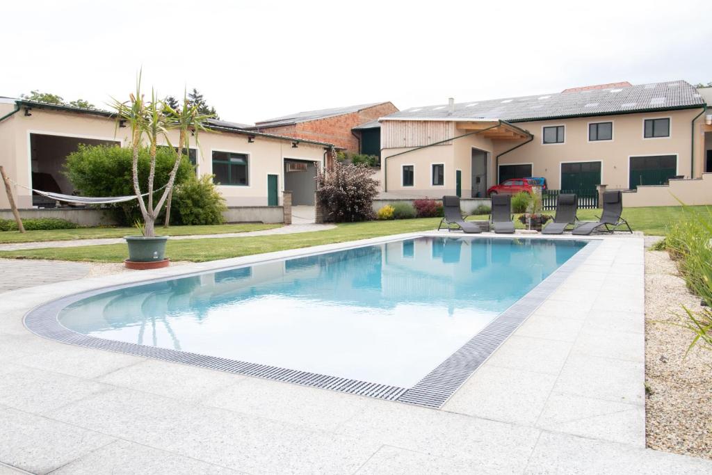 a swimming pool with chairs in a yard at Rebenhof Schwalm in Herrnbaumgarten