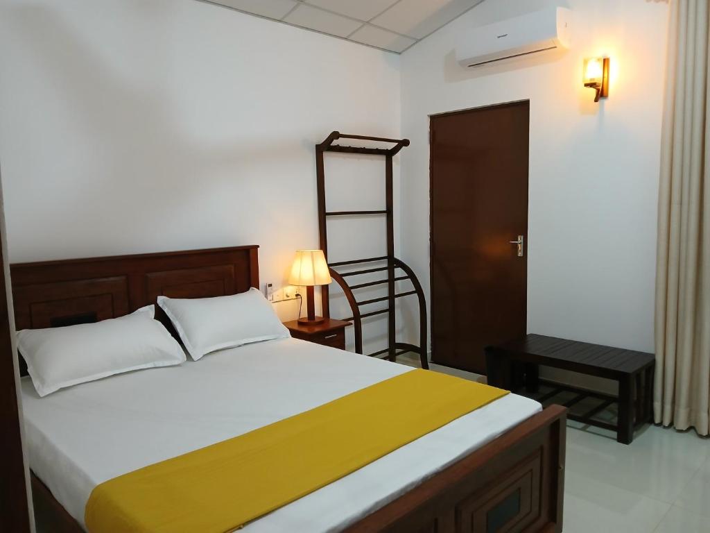 a bedroom with a bed and a ladder and a chair at Noel Villa in Galle