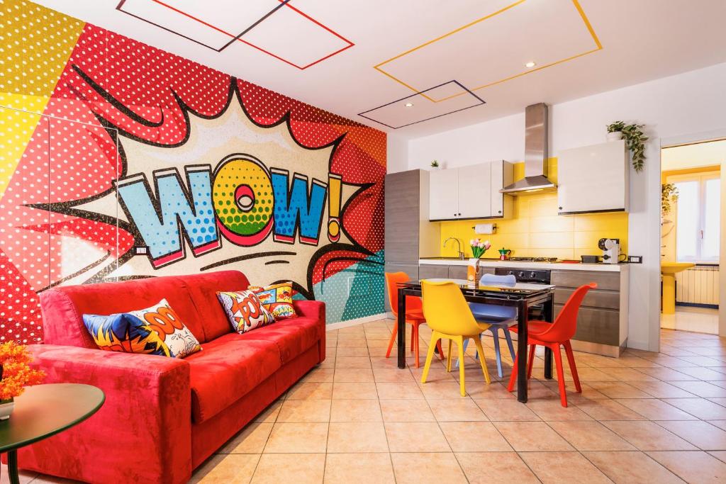 a living room with a red couch and a kitchen at Black & White or Pop Art - Design Apartments with Parking & WiFi in Saronno