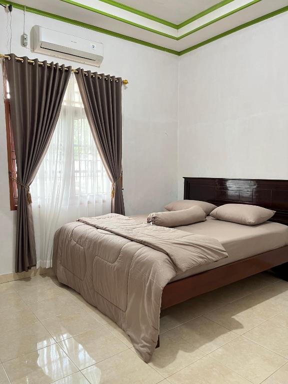 a bedroom with a large bed with a window at Zethira Homestay Syariah in Tabing