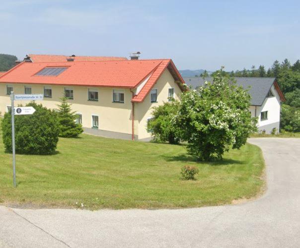 a house with a red roof in a yard at Feriennest Zehetbauer in Hollenthon