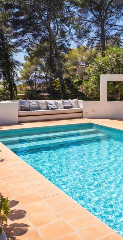 a swimming pool with blue water and lounge chairs at Ca Jardi, Luxury Ibiza-Style villa with private pool, Javea in Jávea