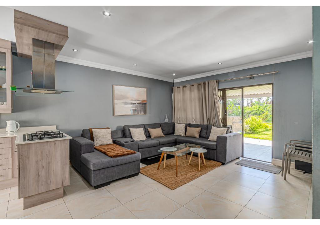 a living room with a couch and a table at Mtunzi Park 18, Scottburgh in Vosburg