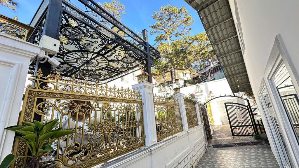 an ornate gold gate on a white house at Mây Villa Garden Đà Lạt in Xuan An